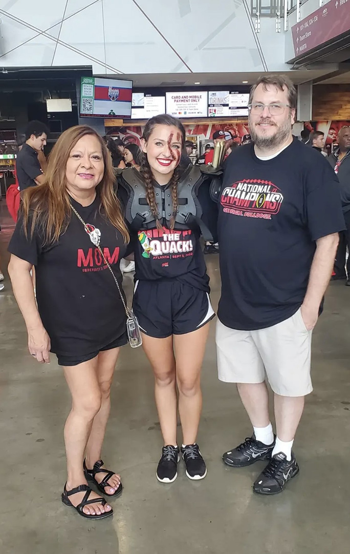 Jenny Swope with her parents at a football game