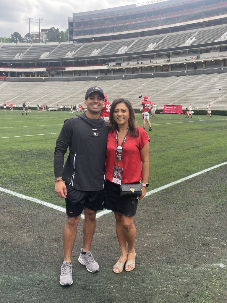 Jayan on the field of Sanford Stadium with his mother, Heena Patel