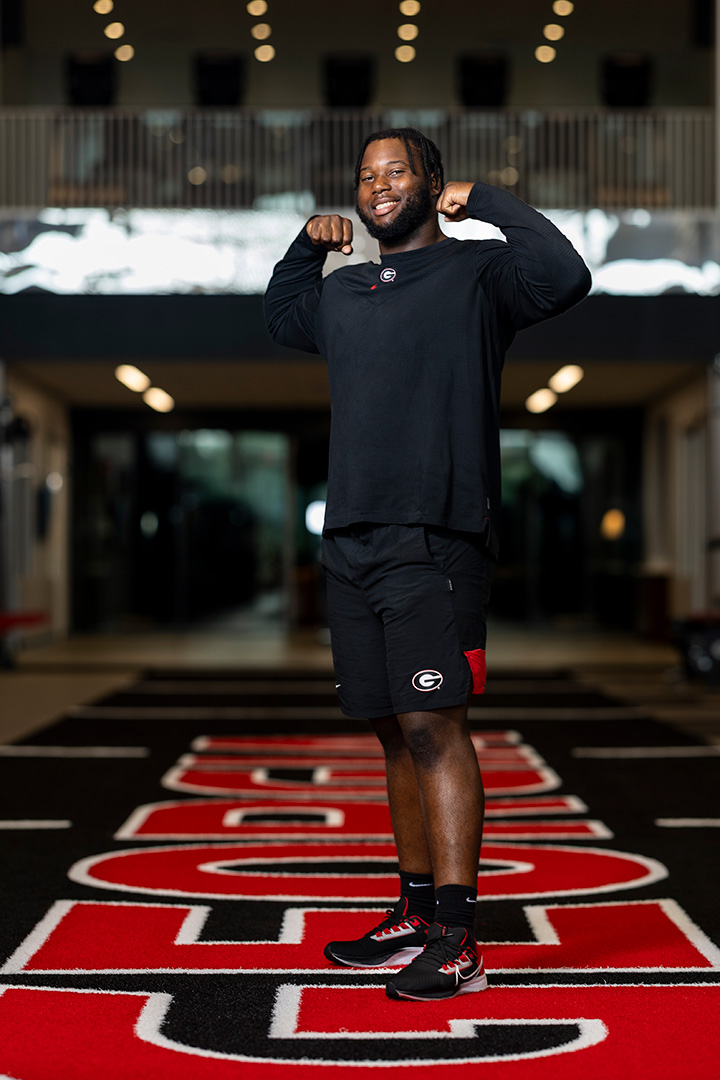 Sedrick Van Pran flexing his arms and smiling