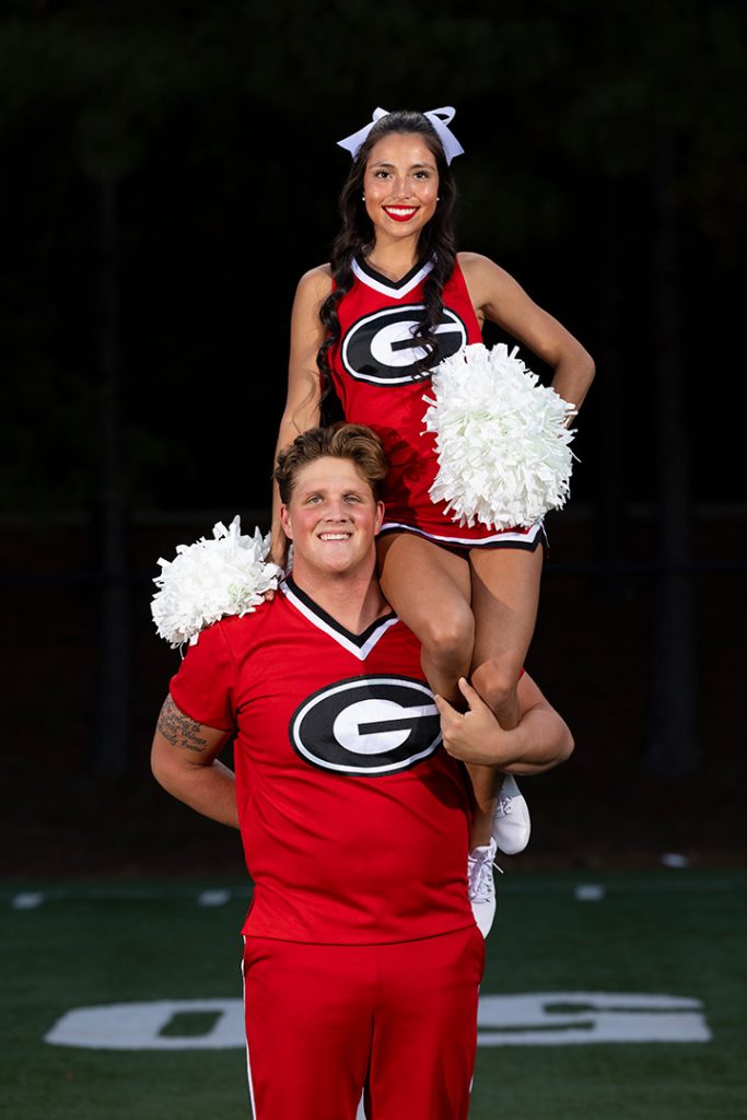 Hamilton posing with a cheerleader on his shoulder