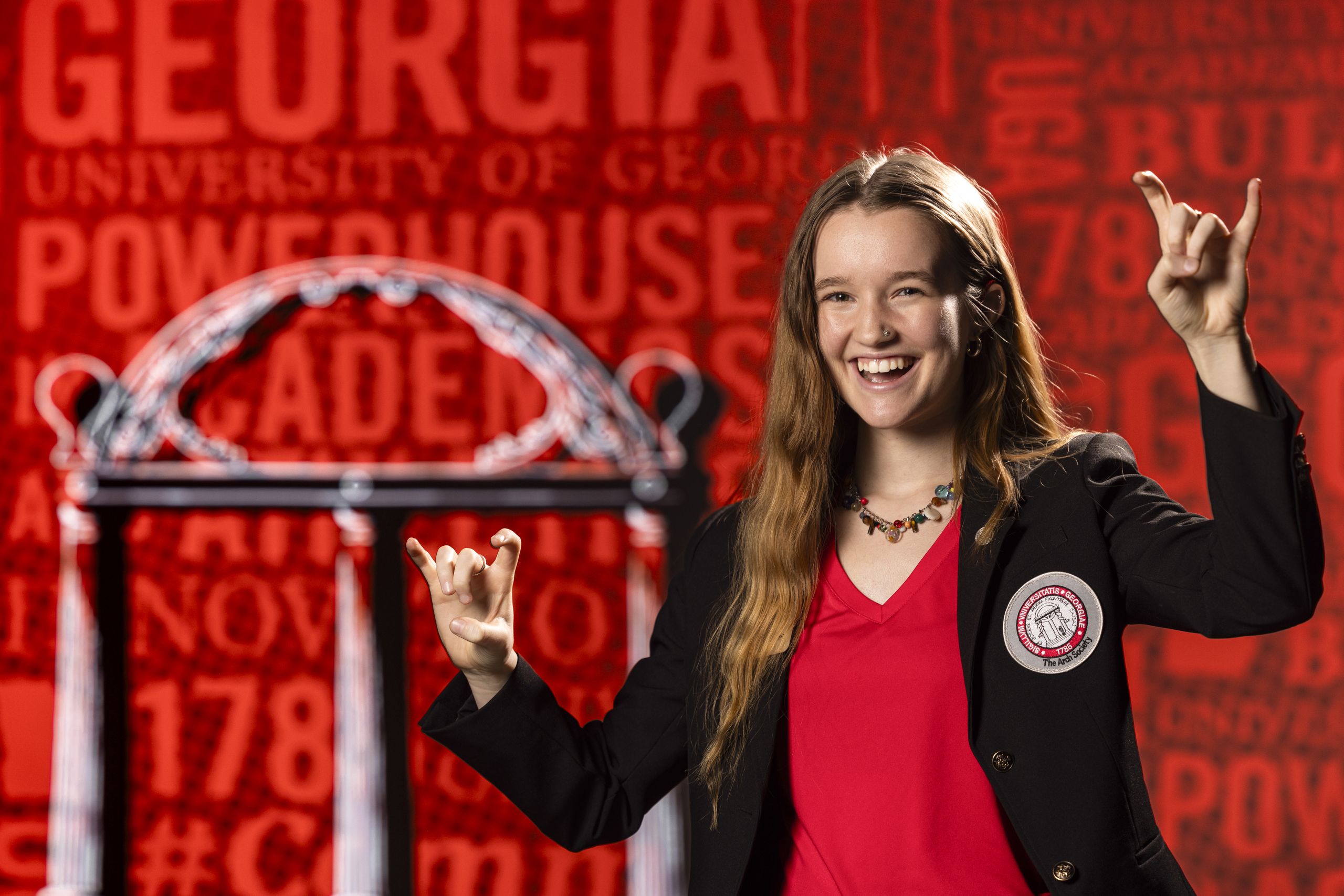 Portrait of Ailey Gustafson, Arch Society member, signing “bulldogs” in the studio for the Game Changers football season campaign.