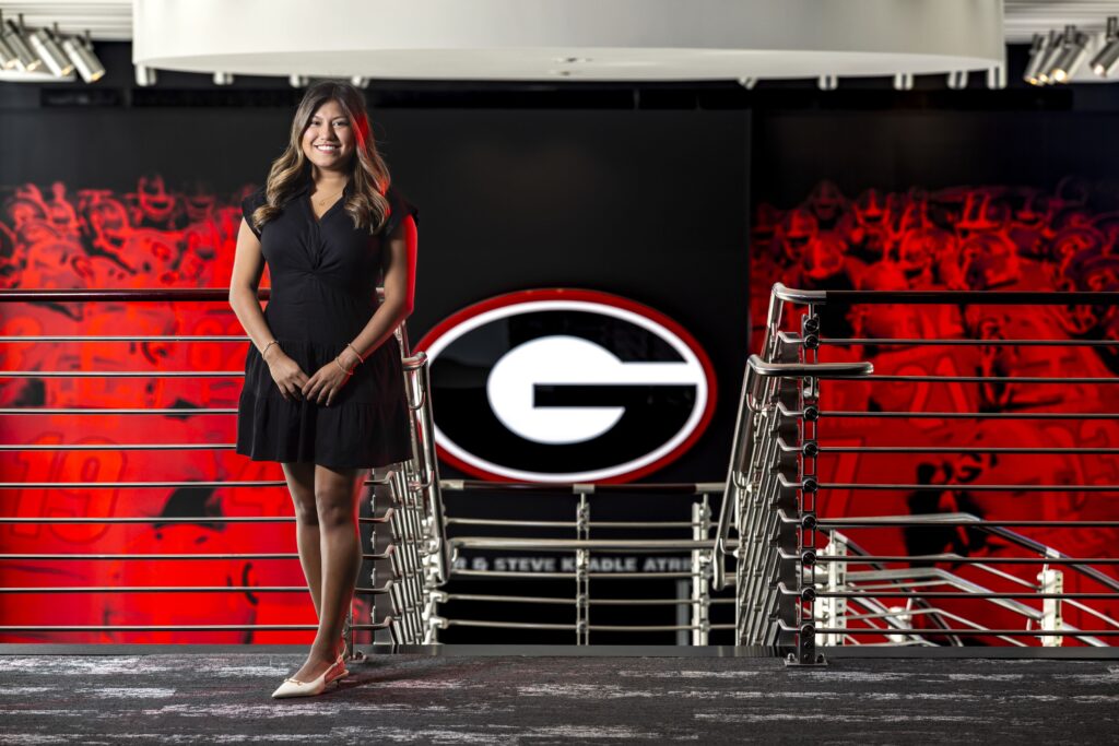 Portrait of Ana Escamilla standing in front of a UGA logo.