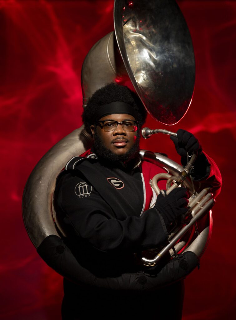 Portrait of Redcoat Marching Band tuba player Travis Mansfield in the photography studio at the Georgia Center.