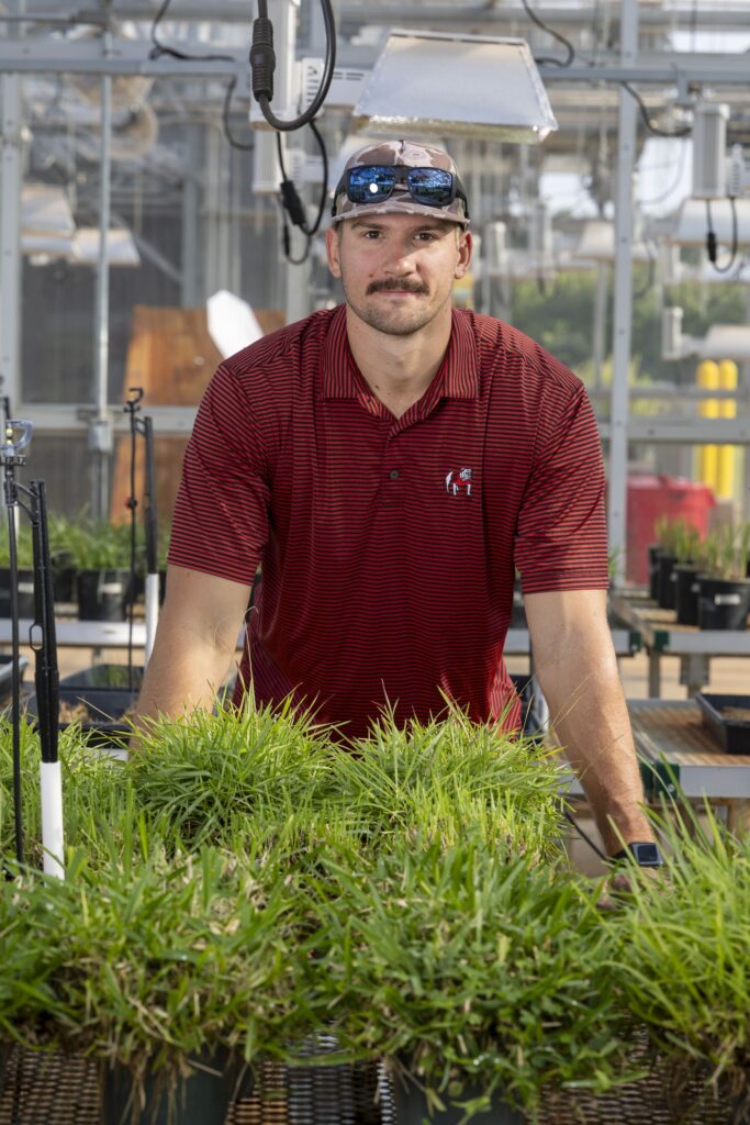 Gavin Shytle photographed in the greenhouse at the Turf Grass Research Facility.