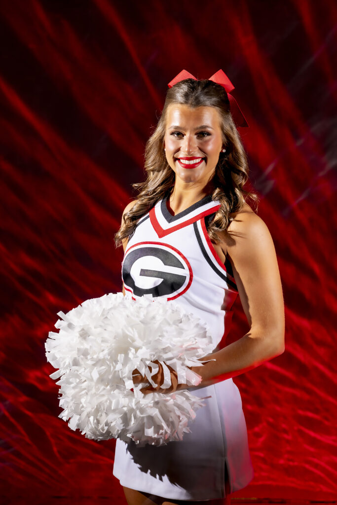 Portrait of Emma Schroeder in a cheerleader uniform holding pompoms.