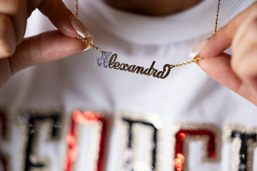 A detail of Alexandra Milano’s necklace that says "Alexandra" during her portrait session inside Sanford Stadium at night. 