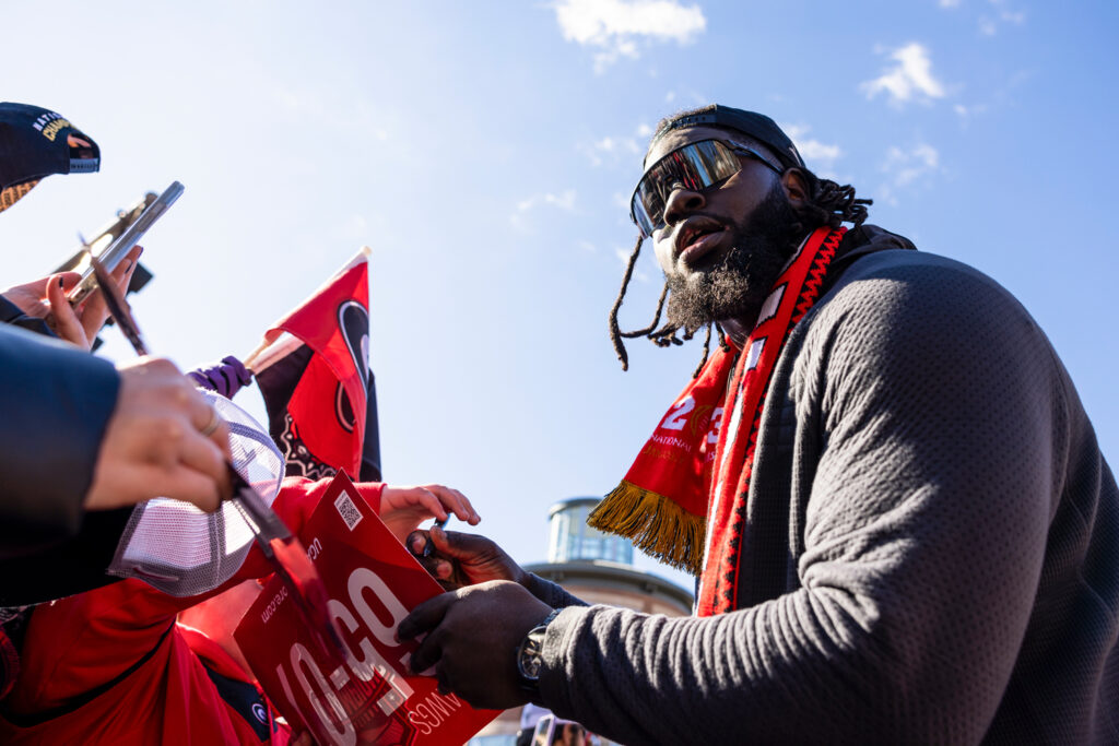 Georgia defensive lineman Nazir Stackhouse (78) signs autographs for fans during the parade celebrating UGA’s 2022 Football CFP National Championship win over TCU.