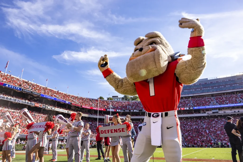 Hairy Dawg shows off his muscles on the Georgia Bulldogs football field while the crowd cheers for the defense.