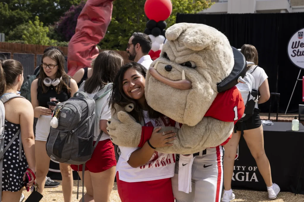 Hairy Dawg, UGA's treasured mascot, hugs a fan at Tate Plaza on UGA's campus during a college event.