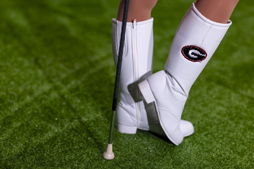 A closeup of feed clad in white majorette boots with the UGA logo.