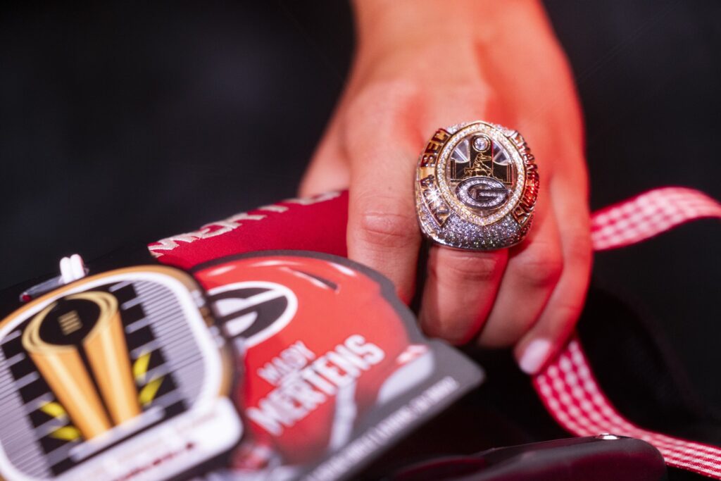 A closeup of a hand wearing a large championship ring.